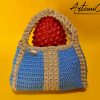 L'immagine mostra una borsa azzurra all'uncinetto con strisce verticali gialle, dotata di un manico coordinato e una chiusura magnetica. Sogno Mediterraneo: il fascino del mare nella tua mano.