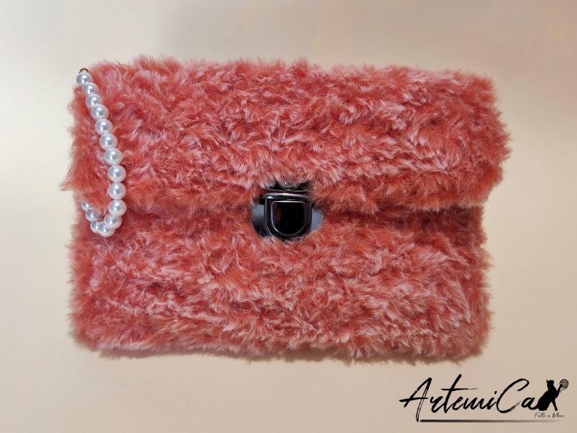 Soffice Abbraccio: Clutch Artigianale in Pelliccia Corallo con Perle e Fibbia Elegante