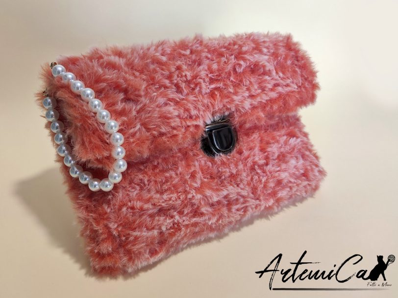 Soffice Abbraccio: Clutch Artigianale in Pelliccia Corallo con Perle e Fibbia Elegante