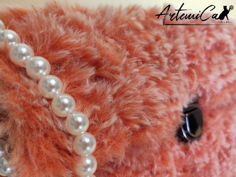 Soffice Abbraccio: Clutch Artigianale in Pelliccia Corallo con Perle e Fibbia Elegante