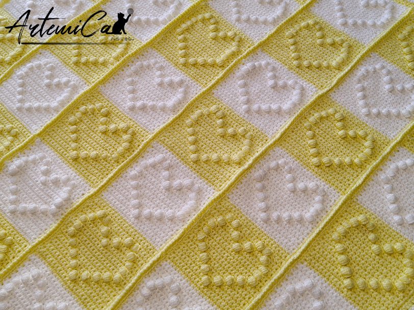 Copertina Scacchi di Cuore: Fatta a Mano all’uncinetto bianco e giallo con cuori in rilievo e pom pom.