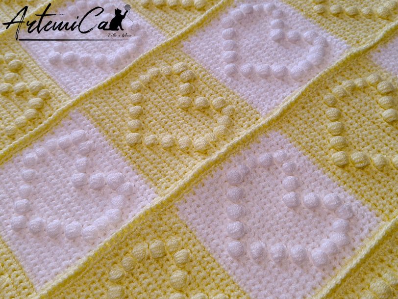 Copertina Scacchi di Cuore: Fatta a Mano all’uncinetto bianco e giallo con cuori in rilievo e pom pom.